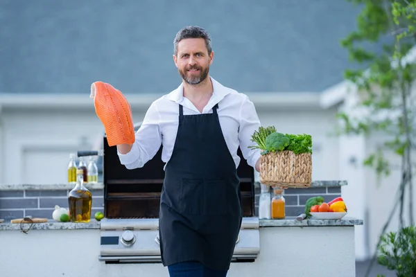 Cook Man Kock Förkläde Hålla Lax Fisk Vid Grill Grill — Stockfoto