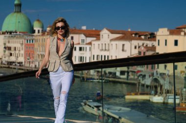 İtalya Venedik 'te yaz tatili. Avrupa 'nın Venedik caddesinde yürüyen şık, şık bir kadın. Venedik 'te moda yaz kıyafetleri giyen bir kadın. Venedik caddesinde poz veren seksi kadın.