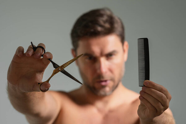 Man with scissors. Man cut hair with hairdressing scissors. Men haircut in studio. Barber scissors. Mens cut beard hair. Guy holding scissors