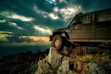 Off road car. Off-road Jeep car on bad gravel road. Wheel close up in a countryside landscape with a muddy road clipart