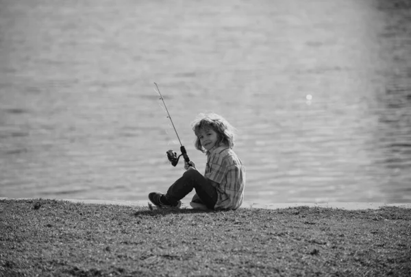 子供の趣味 湖で子供釣り 川でスピナーを持つ少年 興奮した少年釣りの肖像画 男の子とともにロッド — ストック写真