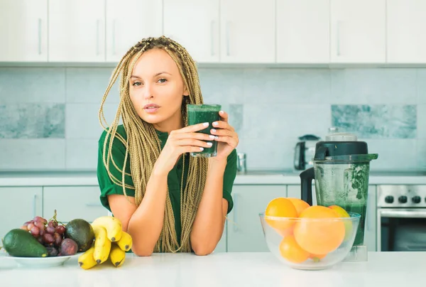 Making smoothie menu. Healthy eating alkaline diet. Healthy Green food. Weight loss. Healthy Lifestyle. Smiling young woman drinking green smoothie in kitchen