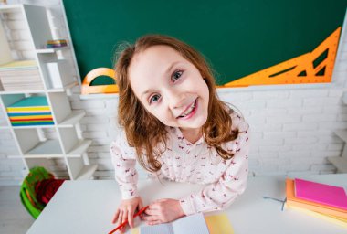 Sınıfta gözlüklü komik bir öğrenci. Tahtada eğlenceli bir çocuk