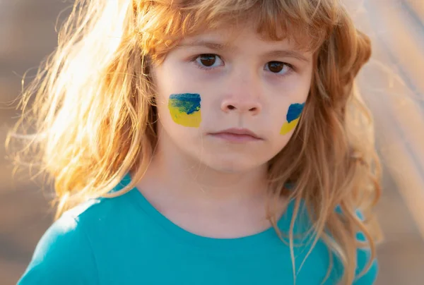 stock image Ukraine flag on kids cheek. No war, stop war, russian aggression. Little ukrainian patriot