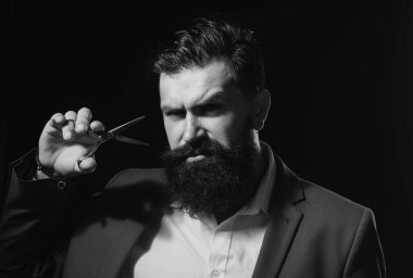 Sakallı adam, uzun sakallı ve bıyıklı bir adam portresi. Berber dükkanı için berber makası. Klasik berber dükkanı, tıraş. Vahşi, ciddi bir erkek, modern siyah saç stili.