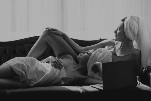 二人の親友の女の子がベッドに横になって話をする いい雰囲気だ ベッドルームでラップトップを使用してレズビアンカップルは 簡単な朝を持っています — ストック写真