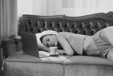 Evde kahve ve dizüstü bilgisayarı olan genç ve çekici bir kadın dinleniyor. Sıcak, tembel bir sabah. Sabahları yatakta uyuduktan sonra güzel bir kız. Yatağın üzerinde gevşemiş kadın manken gecenin bir yarısı uyanıyor.