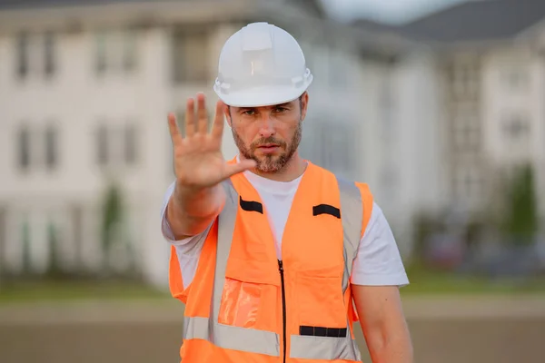 建造者以停止的姿态 没有手 对建造概念很危险 戴头盔的建筑工人在新家附近从事硬帽工程师工作 建筑工地管理员 检查员 — 图库照片