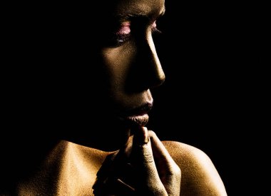 Cadılar Bayramı için Altın Kadın sanat derisi. Güzel makyaj. Güzel kadın ağzında altın dudak parlatıcısı, yakın plan.