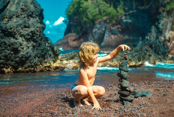 这孩子在海滨筑起了一块石头 儿童海滩游戏 晚上和孩子们一起度假 平衡发展 打造幻想 海洋小孩的肠子 — 图库照片