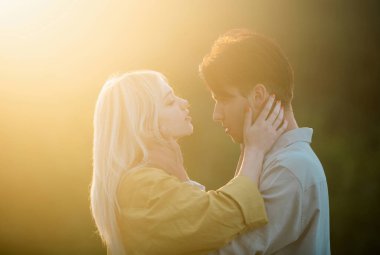 Şehvetli aşıklar gün batımında sarılıp öpüşüyorlar. Birbirine aşık, şehvetli aşıklar kucaklaşıp sarılıyorlar.