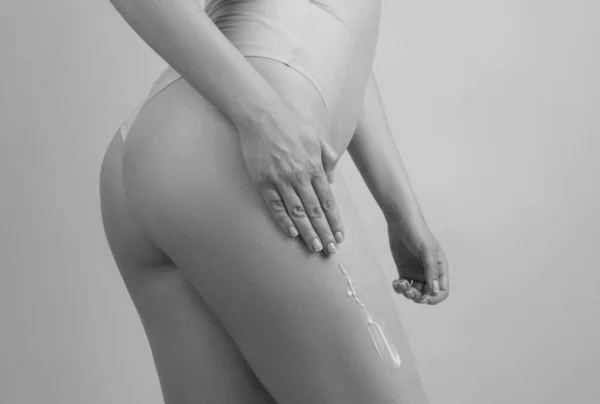 깨끗하고 부드러운 피부를 엉덩이에 크림을 다리에 크림을 바르는 셀룰라이트 돌보고 — 스톡 사진