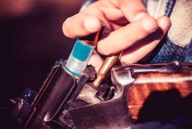 Adam av tüfeğini dolduruyor. Avlanan av tüfekli bir avcı. Amerikan av tüfekleri. Tüfek