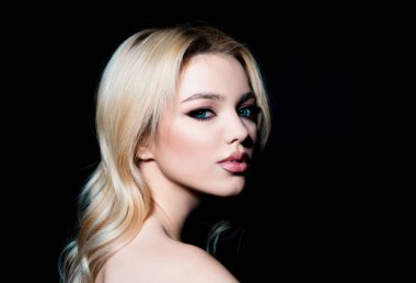 Stüdyoda güzel bir kadın portresi var. Temiz tenli, doğal makyajlı güzel bir kız.