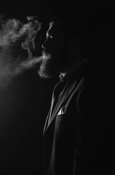 在黑色背景上吸烟 穿西装抽烟的商人 — 图库照片