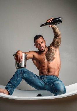 Seksi baştan çıkarıcı soyunan adam banyoda küvete oturur, erkekler şampanya ile tatil yapar. Noel 'i ya da doğum gününü kutlamak için. Özel seks partisi. Kadınlar gününde seksi üstsüz çocuk.