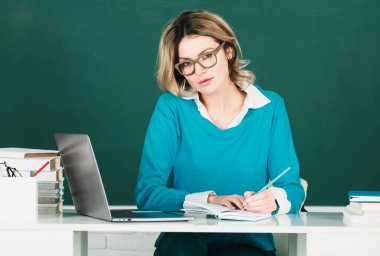 Sınıfta karatahta kitapları olan genç bir bayan öğretmen. Öğrenci kız üniversitede ders öğreniyor. eğitim, lise ve halk konsepti