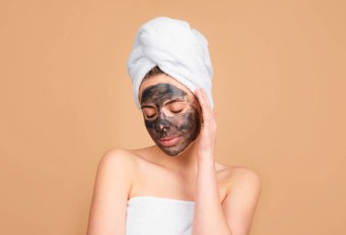 Yüzünde çamur olan güzel bir kız. Kozmetik maske. Güzel surat. Çamur maskesi, yüz maskesi kaplıcası. Kozmetik çamur yüz prosedürü olan güzel bir kadın, spa sağlık konsepti.