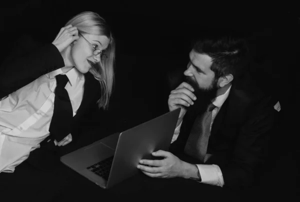 スーツの若いビジネス女性とハンサムなビジネスマンは黒のノートパソコンを使用しています ボスと秘書 — ストック写真