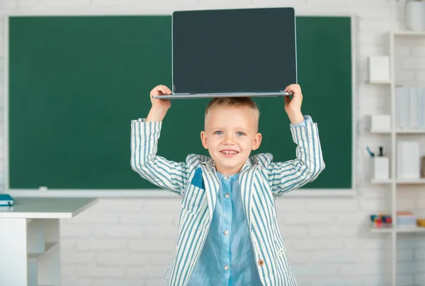 Słodkie Mały Chłopiec Szkoła Trzymając Laptop Głowie Klasie — Zdjęcie stockowe