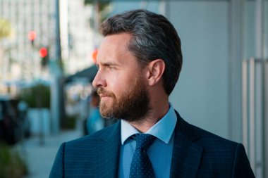 Yakışıklı iş adamı. Dışarıdaki ciddi iş adamının iş portresi. Takım elbiseli bir iş adamı. Ofisteki orta yaşlı iş adamının portresi. Başarı işi