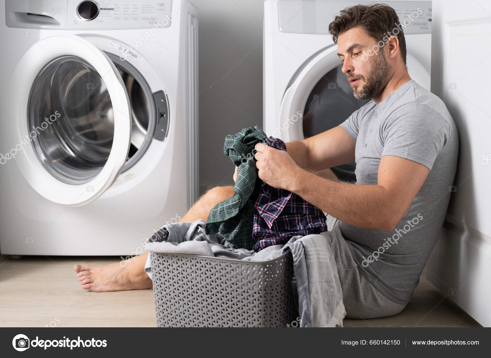男人在洗衣机附近洗衣服丈夫在家里洗衣服性感的家伙在洗衣机里洗衣服家庭观念洗衣机和烘干机洗衣店—  图库照片©Tverdohlib.com＃660142150