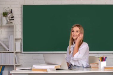 Üniversitede ya da lisede çekici genç bir kız öğrenci. Kameraya bakan neşeli üniversite öğrencisinin portresi