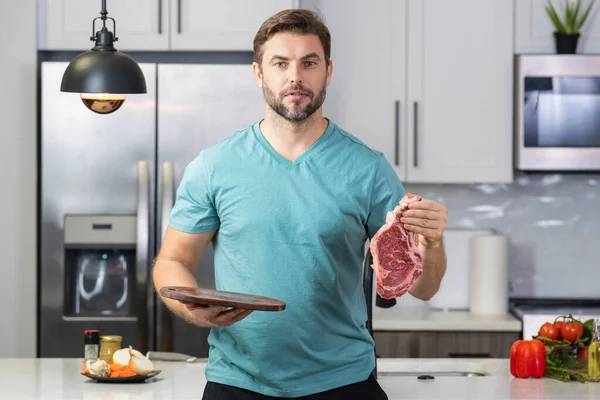厨师在厨房里放生肉牛肉片 英俊的厨师烹调生肉牛肉 餐厅菜单概念 牛肉牛排的概念 中年男人做饭肉 牛肉牛排在厨房里 — 图库照片