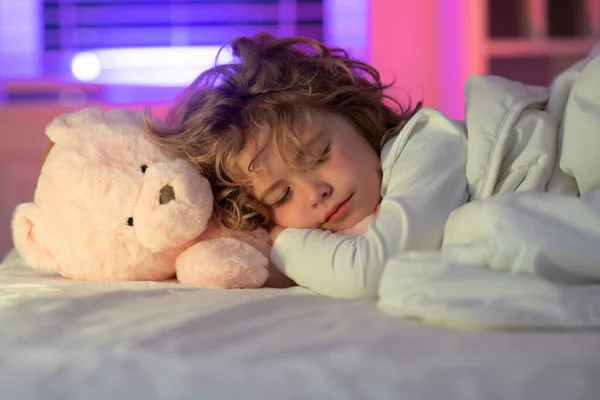 Calm kids sleep. Child boy sleep with a toy teddy bear, napping. Kid sleeping in bed