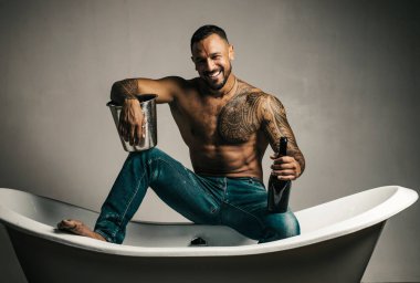 Seksi gülümseyen adam banyoda küvete oturur, erkekler şampanya ile tatil yapar. Noel 'i ya da doğum gününü kutlamak için. Özel seks partisi