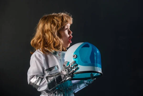 可愛いです少し励起少年宇宙飛行士子供で宇宙服保持ヘルメット上の黒の背景 — ストック写真