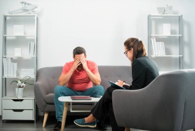 Bunalımlı orta yaşlı adam sorunu terapisi. Psikiyatrist ile terapi seansı sırasında psikolojik sorunlarını tartışan bir adam.