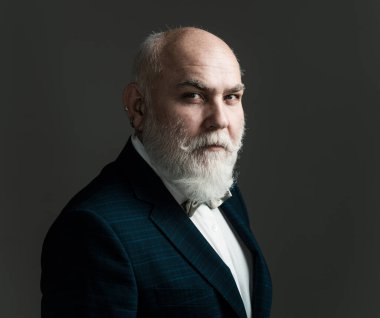 Kıdemli adam. Siyah arka planda izole edilmiş gri saçlı zarif bir son sınıf öğrencisinin portresi.