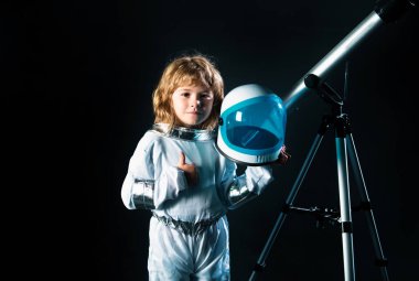 Teleskoplu çocuk astronot kostümü giyiyor. Astronomi ve astroloji kavramı