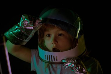 Çocuk astronot kaskı ve uzay kostümü giymiş. Uzay giysili küçük çocuk. Yaratıcı fikirler ve yenilik teknolojisi konsepti. Heyecanlı çocukların yüzünü kapatın.