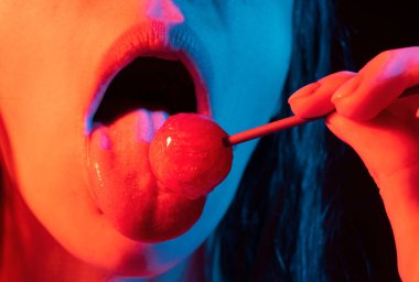 Close up lips with lollipop isolated, sexy blowjob, sensual mouth with lipstick eats sweets. Sexy design for women and girls. Beautiful lips