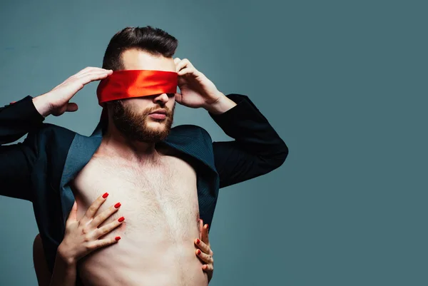Blindfolded. Sexy girl closes eyes of a man. Woman covering man eyes