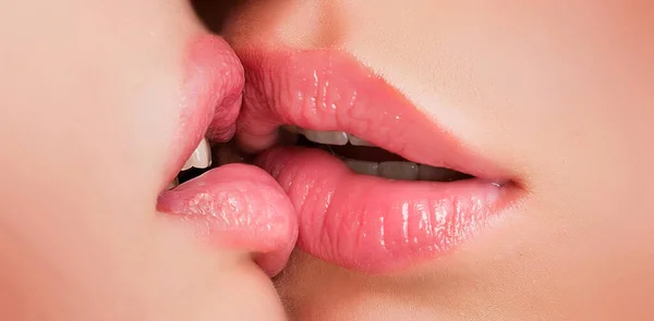 Kiss lesson. Two women friends kissing. Two beautiful sexy lesbians in love. Closeup of women mouths kissing. Passionate kissing. Sexy plump full lips. Lipstick and lipgloss
