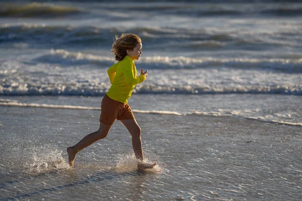 晴れた夏の日には波の海の近くの湿った海岸で走っている屈託のない少年を追放した 夏のビーチで走っている子供 気をつけて 夏の海を走る興奮した子供 かわいい子供は夏の海で走る — ストック写真