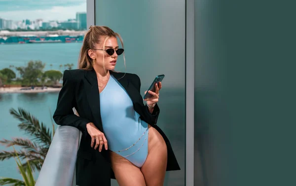 Sexy business woman. Beautiful secretary with phone. Sexy businesswoman in a fashion suit. Elegant fashionable business woman wearing trendy clothes talking on phone. Business woman using phone