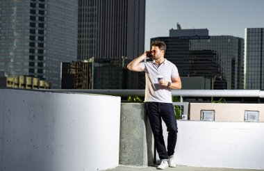 Şehir merkezinde telefonda sohbet eden sıradan yakışıklı bir adam. Havalı gözlükler takan ve dışarıda polo oynayan iyi giyimli bir adam. Telefon kullanan bir iş adamı. Şehirdeki erkek telefon görüşmeleri