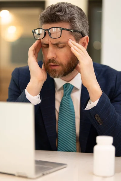 ラップトップ上の頭痛や眼の緊張 ストレスと疲労眼精疲労を持つビジネスマン コンピュータの仕事の後で疲れた目をこすりビジネスマン 視力障害 視力不良感眼疲労痛 — ストック写真