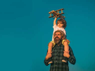 Baba ve oğul dışarıda eğleniyor. Çocuk pilot ve baba uçakla