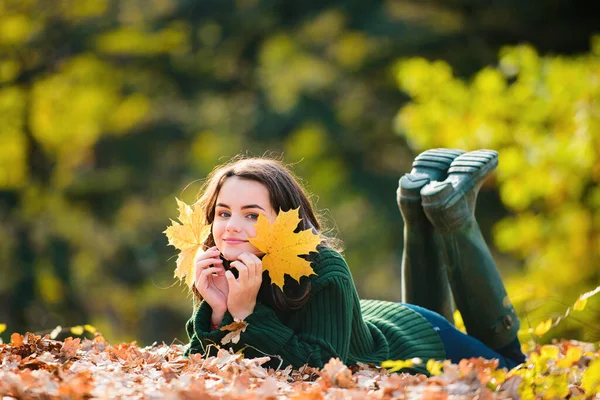 在秋天的公园里 一个微笑的小女孩在秋天的枫叶上躺在室外 一个美丽微笑的少女的画像 想拍照的少女 — 图库照片