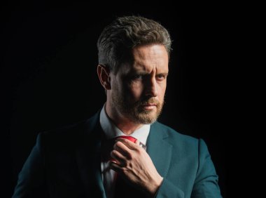 Siyah arka planda takım elbiseli başarılı orta yaşlı iş adamının portresi. Kendine güvenen bir iş adamı. İnsanlar, iş, moda ve giysi konsepti, takım elbiseli adama yakın çekim ve...