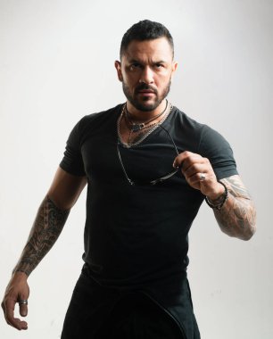 Yakışıklı genç adamın portresi güneş gözlüğü tutuyor. Moda adamı.