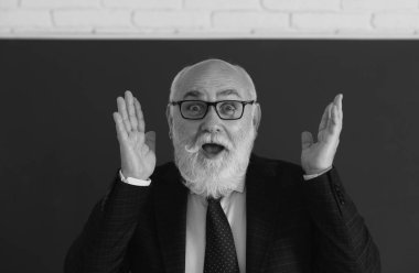 Komik öğretmenin şaşırmış yüzü. Tahtadaki heyecanlı kıdemli profesör