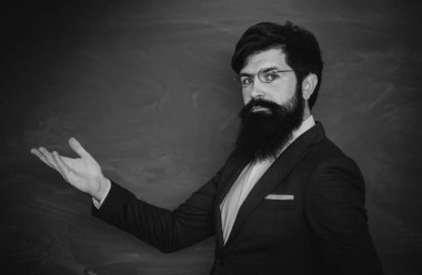 Okula ve mutlu zamanlara geri dönelim. Öğretmenler günü - bilgi ve eğitim okulu kavramı. Tahta masasının yanındaki sınıfta dost öğretmen. Chalkboard kopyalama alanı