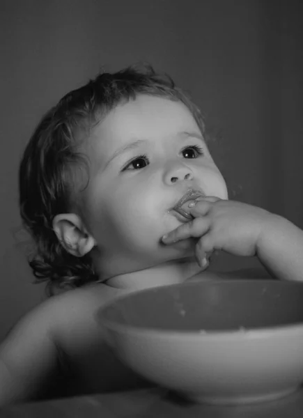 小孩在厨房里用盘子和勺子吃汤 — 图库照片