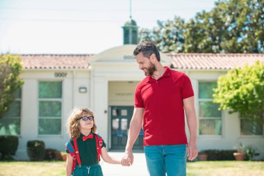 Baba ve oğul okuldan döndükten sonra babalarıyla koşuyorlar. Okul çocukları eğitim ve açık hava konsepti